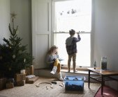 Niños juntos en la sala de estar con árbol de Navidad - foto de stock