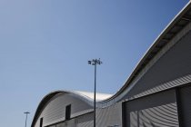 Gebogenes Dach der Lagerhalle und blauer Himmel — Stockfoto