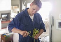 Skillful caucasian electrician cutting wires in home — Stock Photo