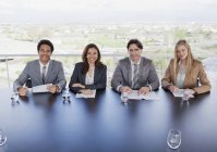 Портрет улыбающихся деловых людей, сидящих за столом в конференц-зале — стоковое фото