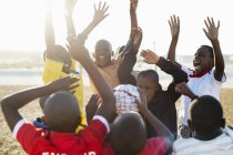 Meninos africanos aplaudindo juntos no campo de sujeira — Fotografia de Stock