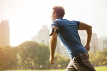 Side view of man running in urban park — Stock Photo