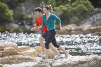 Couple running on rock formations — Stock Photo