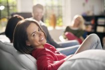Lächelnde Frau entspannt sich auf Sofa — Stockfoto