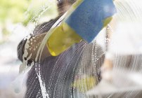Geschickter Kaukasier wäscht Fenster mit Schwamm — Stockfoto