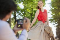 Man photographing woman in park — Stock Photo