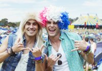 Portrait of men in wigs gesturing at music festival — Stock Photo