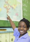 Étudiant afro-américain utilisant la carte du monde en classe — Photo de stock