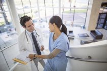 Лікар і медсестра розмовляють по сходах в лікарні — стокове фото