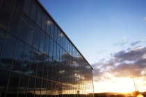 Небо восходящего солнца отражается в окнах современных зданий — стоковое фото
