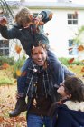 Padre e figlio giocano in foglie autunnali — Foto stock