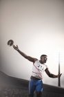 Track and field athlete throwing discus — Stock Photo