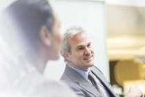 Hombre de negocios sonriente en la reunión en la oficina moderna - foto de stock