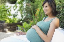 Pregnant woman relaxing outdoors — Stock Photo
