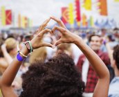 Femme en forme de cœur avec les mains au festival de musique — Photo de stock