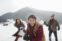 Porträt verspielter Freunde, die Schneebälle ins Feld werfen — Stockfoto