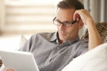 Hombre pensativo usando tableta digital - foto de stock