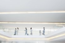 Geschäftsleute laufen auf erhöhtem Gehweg im Flughafen — Stockfoto