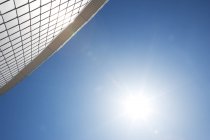 Sun by modern building in blue sky — Stock Photo