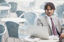 Empresário usando laptop no café da calçada — Fotografia de Stock
