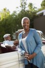 Lächelnde ältere Frau lehnt an Cabrio — Stockfoto
