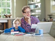 Bored father and son working at table — Stock Photo
