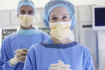 Cirujanos de pie en quirófano moderno - foto de stock