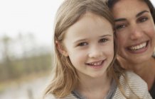 Close up portrait of smiling mother and daughter — Stock Photo