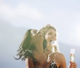 Молодые привлекательные женщины пьют шампанское на открытом воздухе — стоковое фото