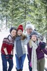 Família caucasiana feliz brincando na neve juntos — Fotografia de Stock