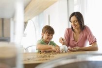 Mother and daughter filling piggy bank — Stock Photo