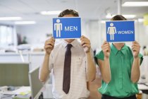 Les gens d'affaires tenant des hommes et des femmes signes — Photo de stock