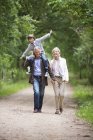 Пара прогулок с внуком по сельской дороге — стоковое фото