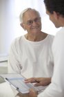 Arzt im Gespräch mit älterer Patientin im Krankenhauszimmer — Stockfoto
