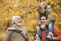 Tres generaciones de hombres sonriendo en el parque - foto de stock