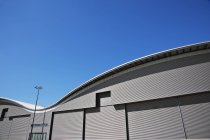 Gebogenes Dach der Lagerhalle und blauer Himmel — Stockfoto
