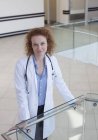 Doctor apoyado en barandilla en el pasillo del hospital - foto de stock
