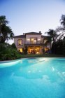 Luxury swimming pool and villa at dusk — Stock Photo