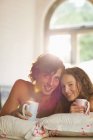 Junges glückliches Paar beim gemeinsamen Kaffee im Bett — Stockfoto