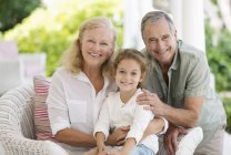 Older couple with granddaughter on porch — Stock Photo