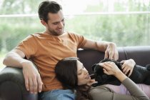 Couple relaxing with dog on sofa at modern home — Stock Photo