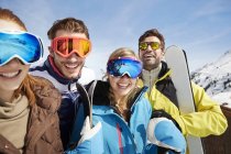 Amigos llevando esquís en la cima de la montaña - foto de stock
