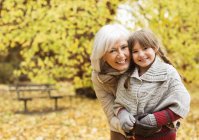 Літня жінка і онука посміхаються в парку — стокове фото