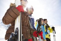 Amigos de pé com esquis no topo da montanha — Fotografia de Stock