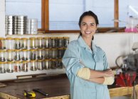 Skillful caucasian woman smiling in workshop — Stock Photo