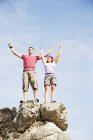 Climbers cheering on rocky hilltop together — Stock Photo