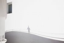 Moderne Architektur, Schatten eines Geschäftsmannes an Geländer gelehnt — Stockfoto