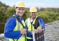 Skillful caucasian workers smiling on roof — Stock Photo