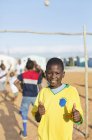 Africano ragazzo sorridente in sporco campo — Foto stock