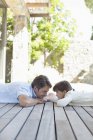 Père et fille allongés sur le porche — Photo de stock